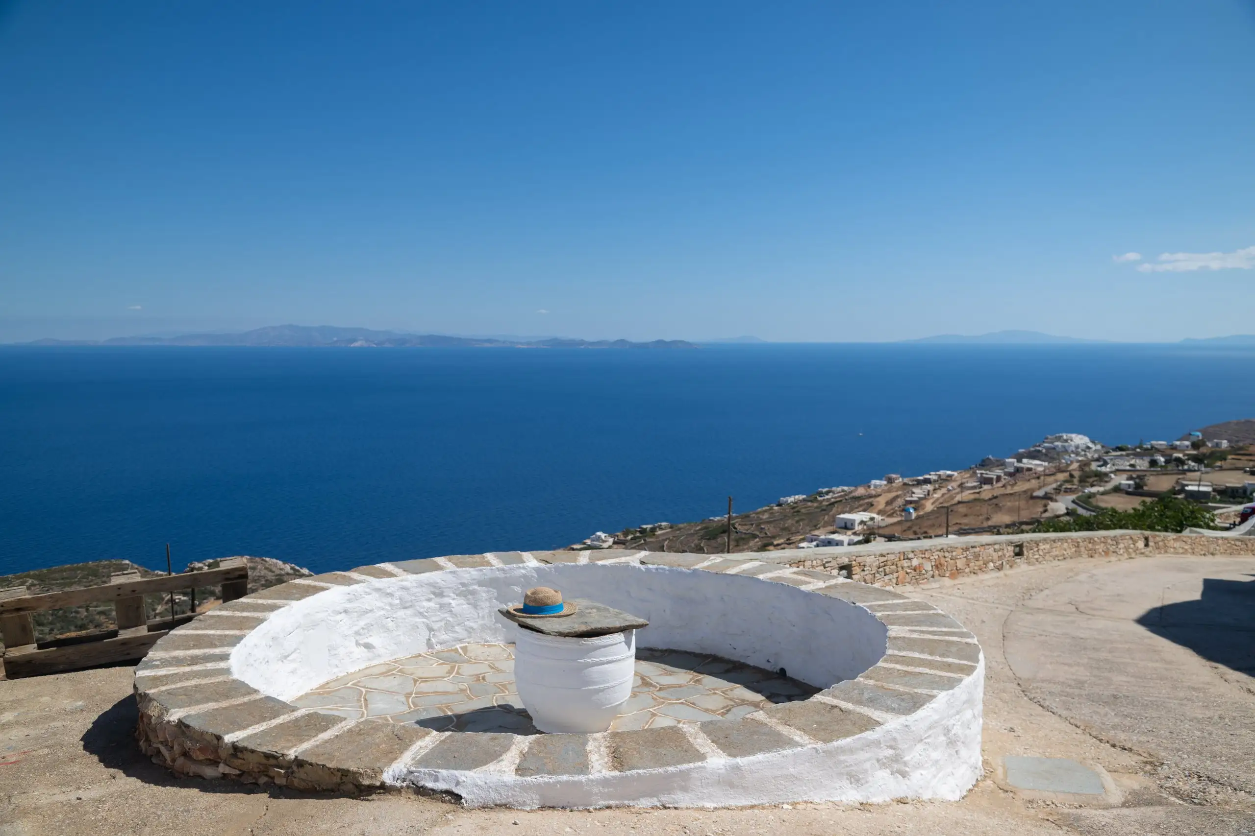 Πανοραμική θέα στο Αιγαίο από ασβεστωμένη πέτρινη αυλή του Windmill Villas