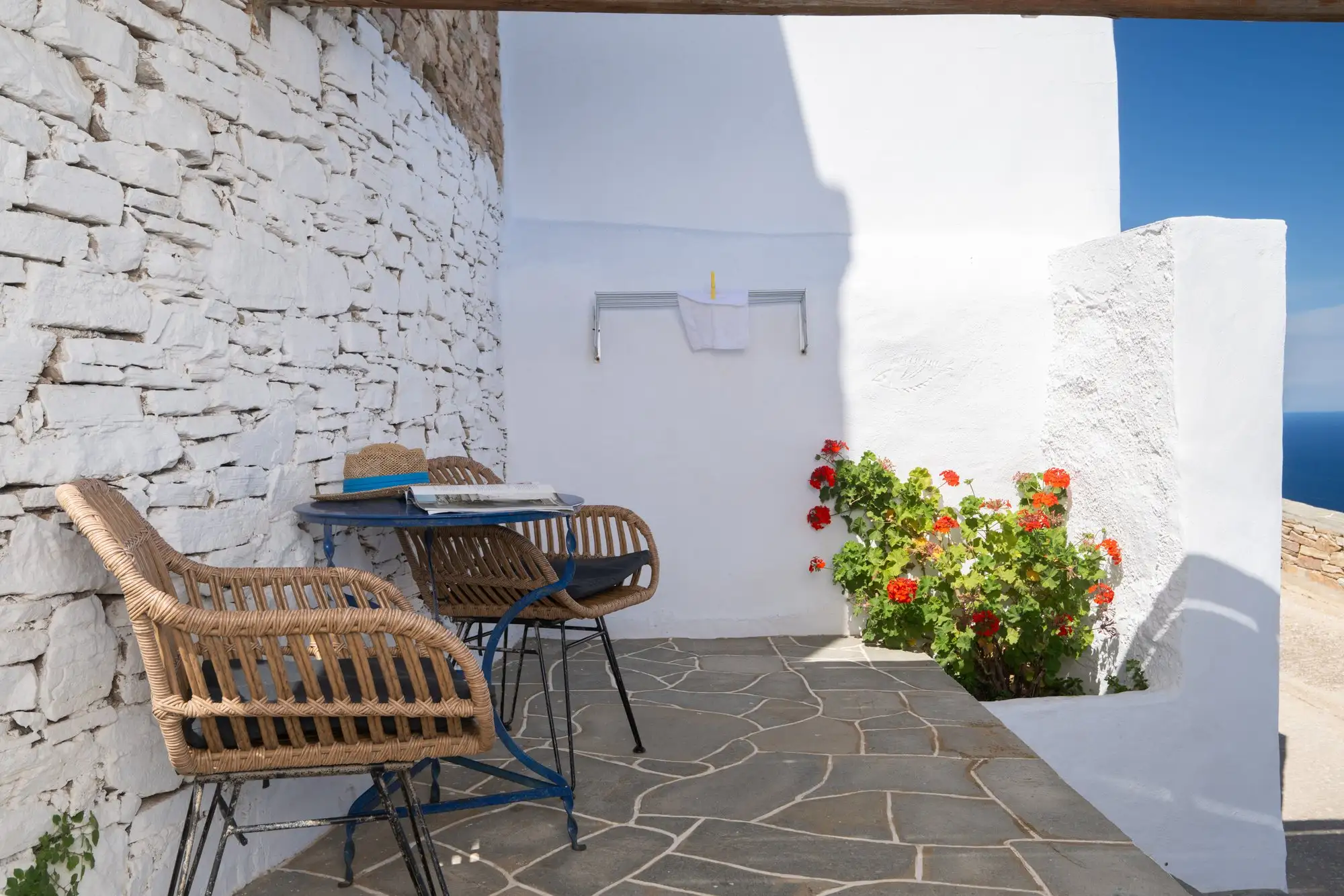 Studio Kleio: ψάθινες καρέκλες και γεράνια στη βεράντα