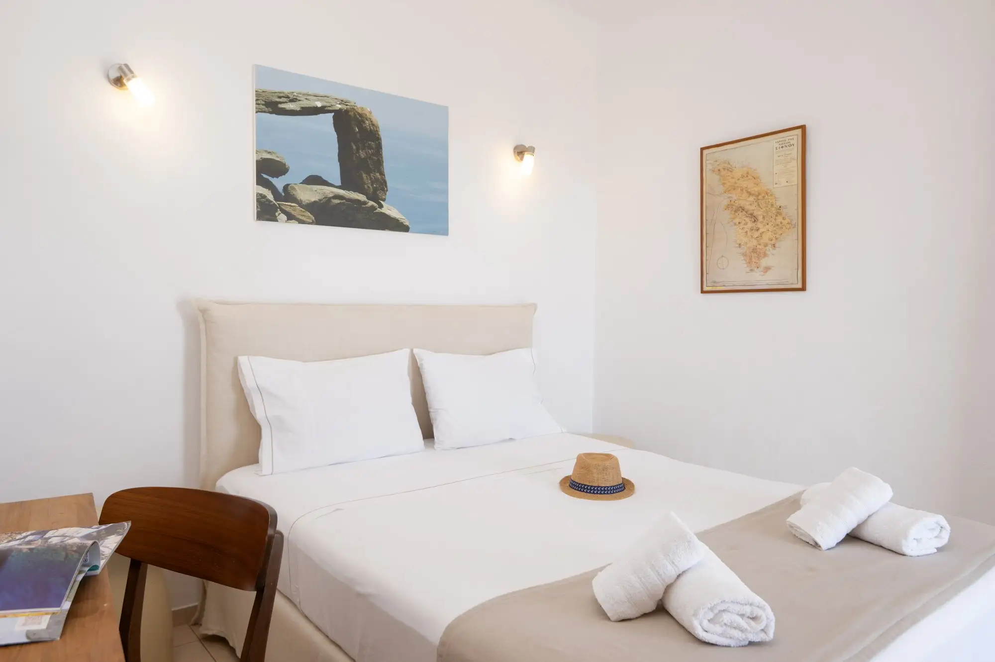 Studio Thalassa: το κρεβάτι και ο χάρτης της Σίφνου στον τοίχο
